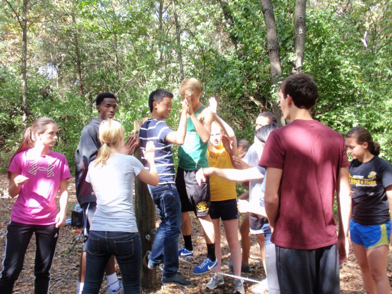 A group of students gather for a team building exercise in the forest 